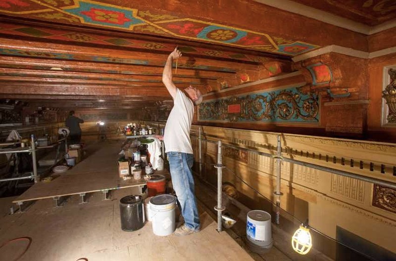 A worker restores the gilding to one of the ceilings in the Saenger, by hand.  