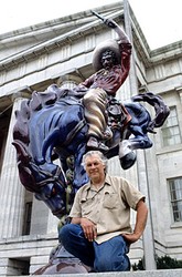 Creator of the Blue Mustang, Artist Luis Jiménez, posing with his work Vaquero.