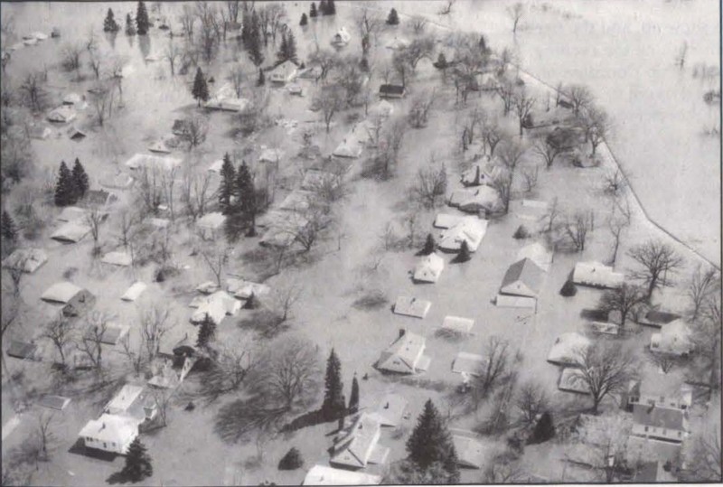 Aerial image of flood waters filling neighborhood to house roofs.