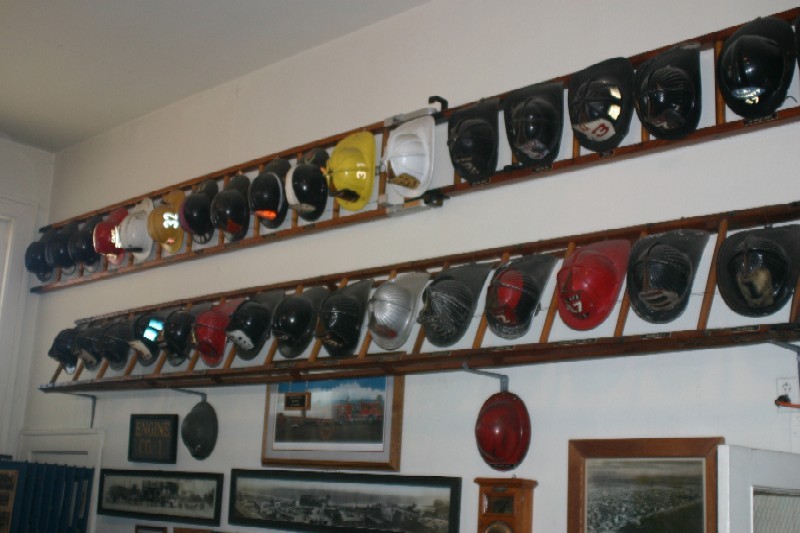 Vintage fire fighting helmets on display.