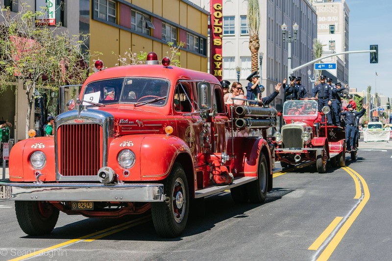 Firefighters and vintage vehicles participating in a local parade