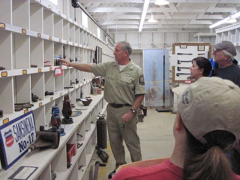 A ranger discussing the various oil industry artifacts to visitors.