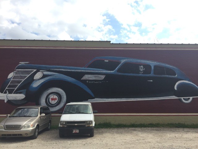 Present Day Mural of Abraham Lincoln driving a Lincoln on the side of the the Theatre