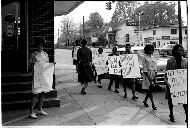 Protesters marching in front of parlor at a later protest in 1962. Photo from the Herald-Sun.