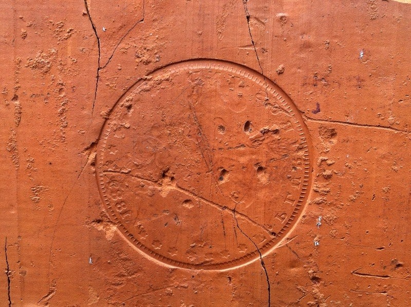 The impression of an 1889 coin on the building's exterior.