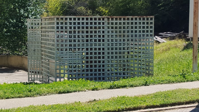 An original jail cell sits in the parking next to the building.