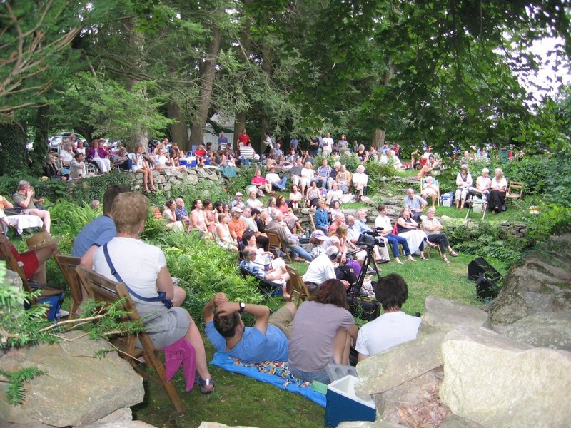 People enjoying a folk tradition concert in the house's sunken garden.