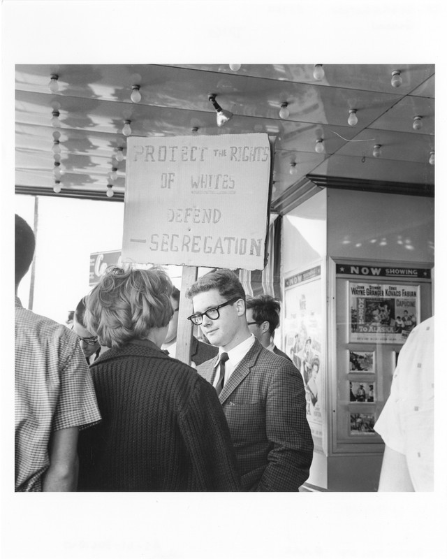 Pro-segregation protesters hold up signs outside the theater in a form of counter protest to the stand-ins.
AS-61-30610-7, Austin History Center, Austin Public Library.