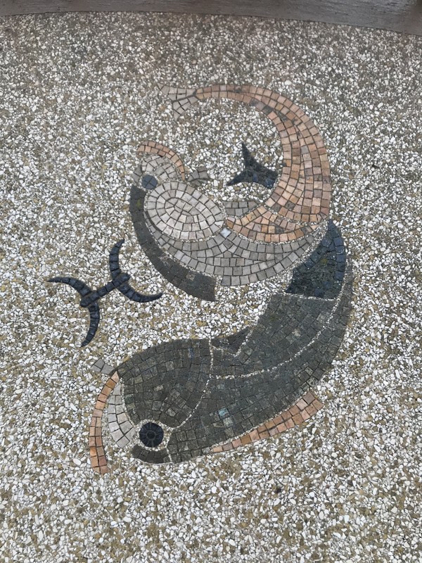 An image of two gray and yellow fish formed from small tiles.
