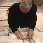 Father Don Higgs placing relics of St. Francis of Assisi, Saint John XXIII, Saint Elizabeth Ann Seton, and Saint Kateri Tekakwitha into the alter.