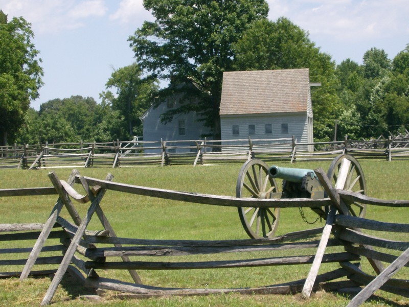 A cannon and the Watt House overlook the battlefield.