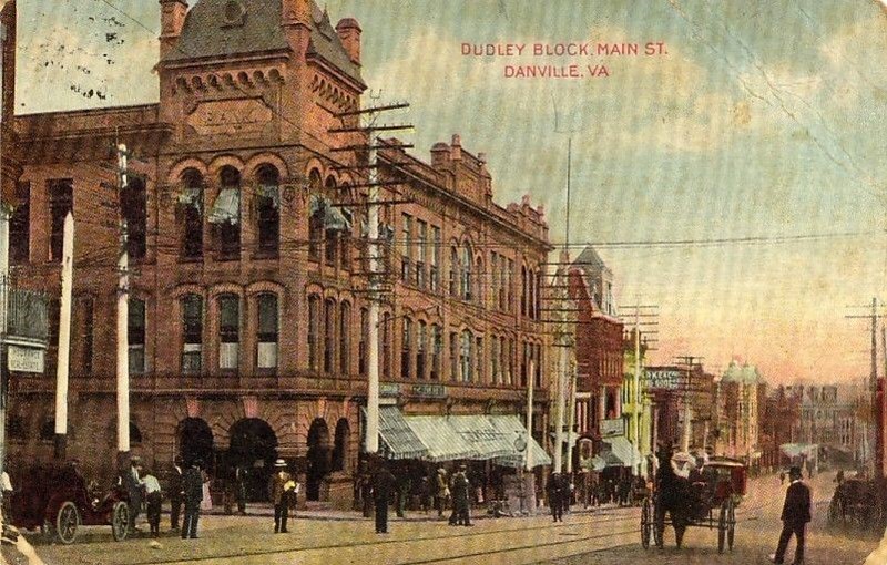 A May 1919 fire nearly gutted the entire three-story Dudley Block (corner #1), which has anchored the corner of Main Street with North Union since 1901. Notice that the tower no longer exists. There is a motorcar, horse & buggy, and trolley tracks.