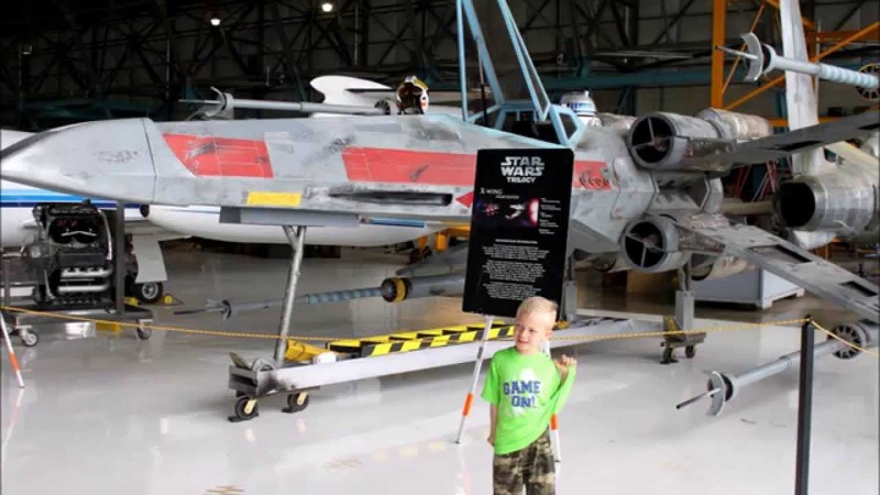 A future x-wing pilot in front of his x-wing fighter.