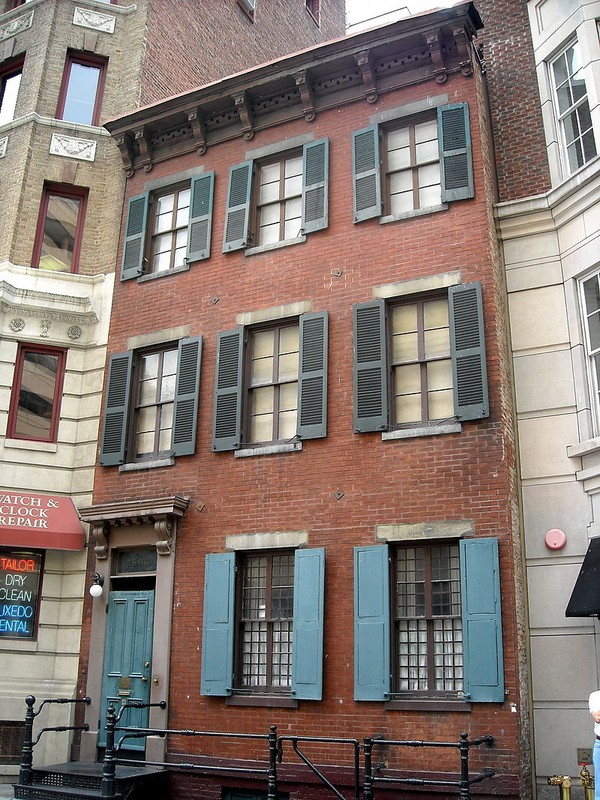 The facade of the Alibi Club building, nestled between other historical structures on Eye Street.