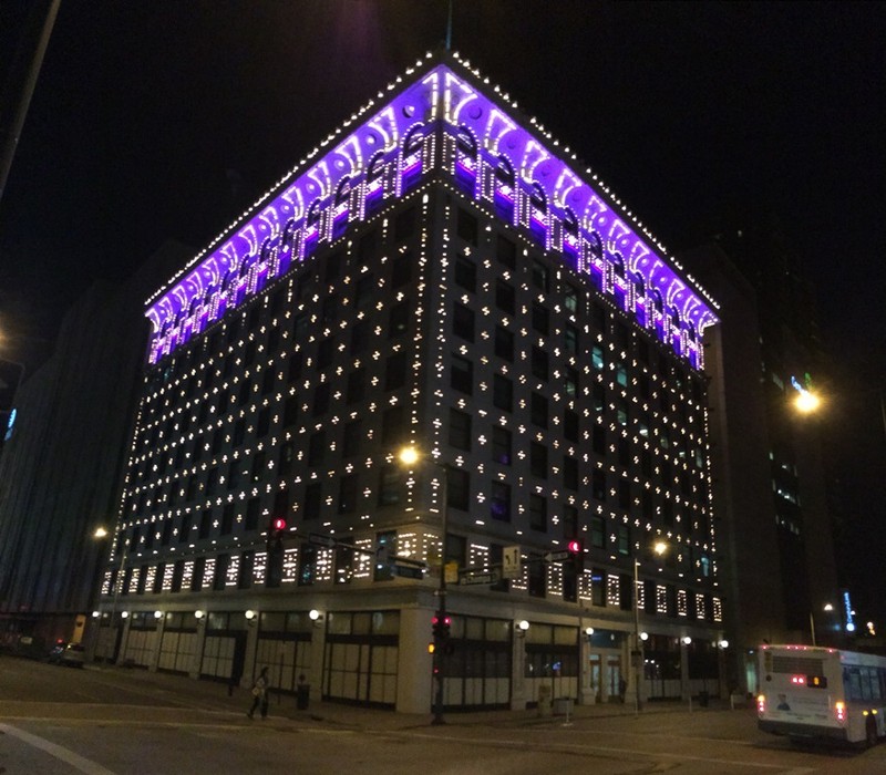 The Denver Gas and Electric Building lit up at night.