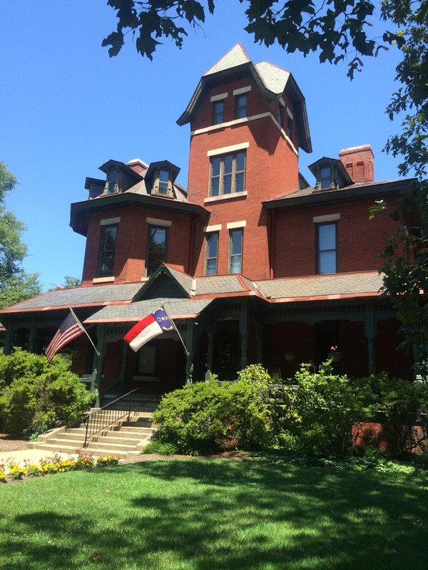 Another view of the front, western facade taken at an angle. US and North Carolina flags waving in the summer breeze.