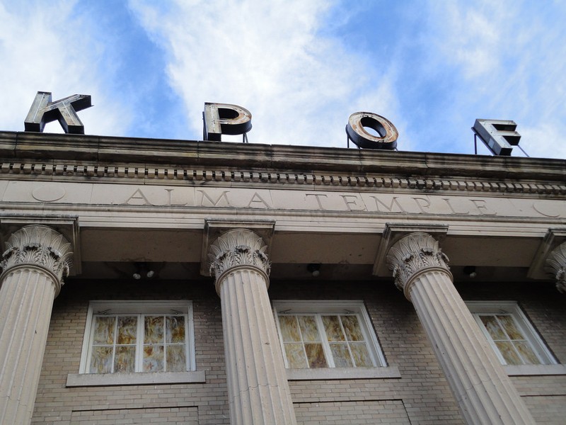 Neon call letters of the KPOF sign atop the Neoclassical facade of the Alma Temple. Photo by Paul Sableman. Licensed under Creative Commons.