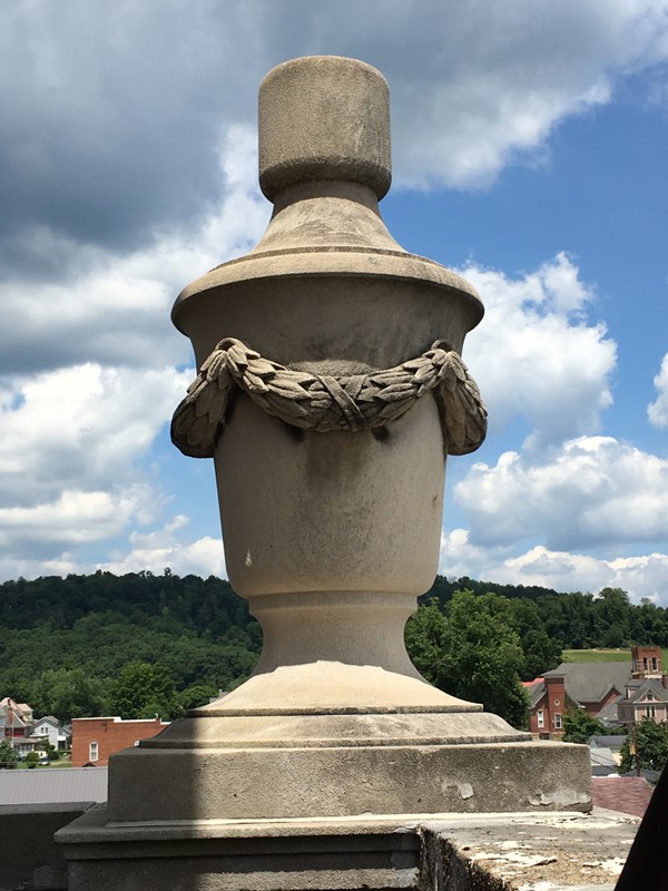 Four urns adorn the four-cornered ledge just below the bell tower. 
(Photograph by author)