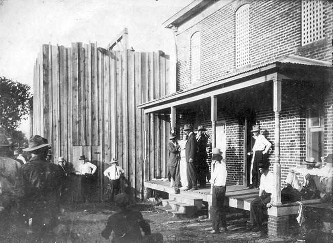 Old Jail Building and Arthur Tillman standing on the porch claiming his innocence and telling the crowd goodbye