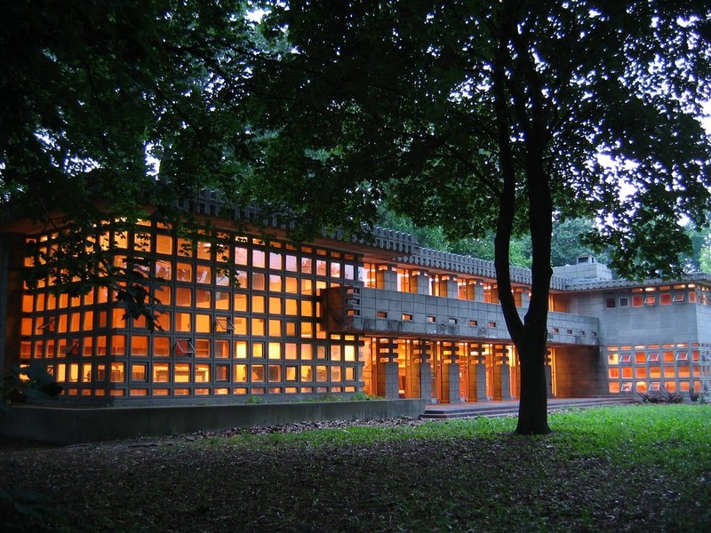 Lights on inside at dusk showcase the home's unique block windows