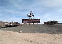 Apache Attack Helicopter and Two M1 Abrams Tanks are located right outside the main gate.