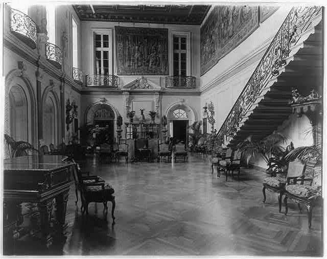 The lavish ballroom of the Anderson house, which includes ornate iron balconies and a staircase, tapestries, and decorative furniture. Courtesy of the Library of Congress.