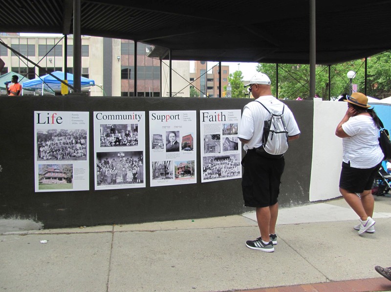 Local festival attendees read educational placards made by AACHM