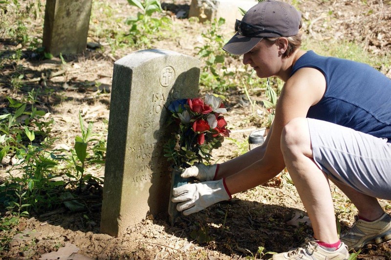 Huntington resident, Leigh Anne Shelton places flowers at the grave of WWI veteran Isaac Jones during cleanup efforts in 2013