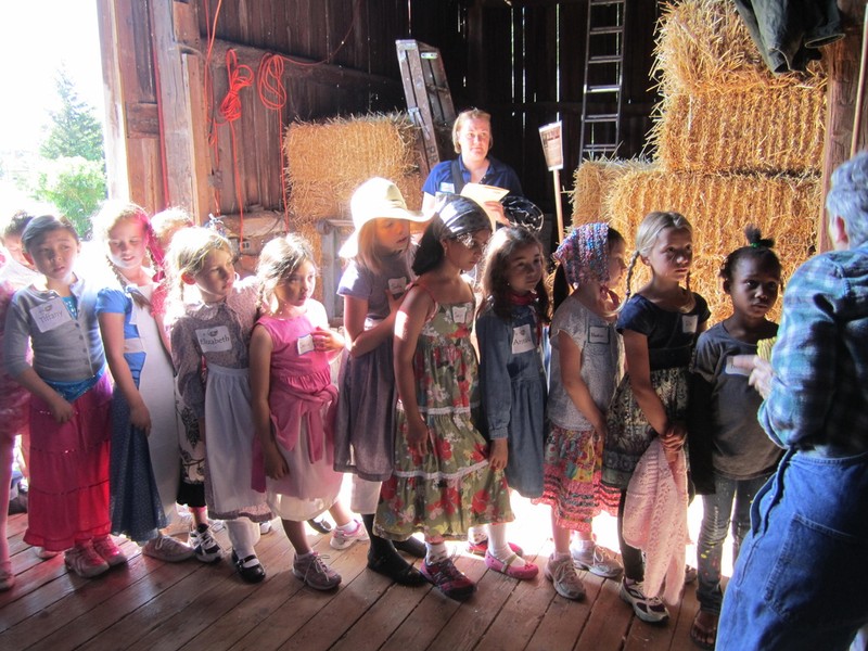 Schoolchildren listen to a program held in the barn