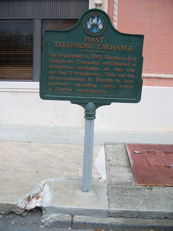 Marker in front building commemorating its use as the city's first telephone exchange