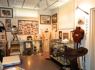 A photo of some artifacts exhibited in the museum including authentic saddles and farming equipment from early settlers.