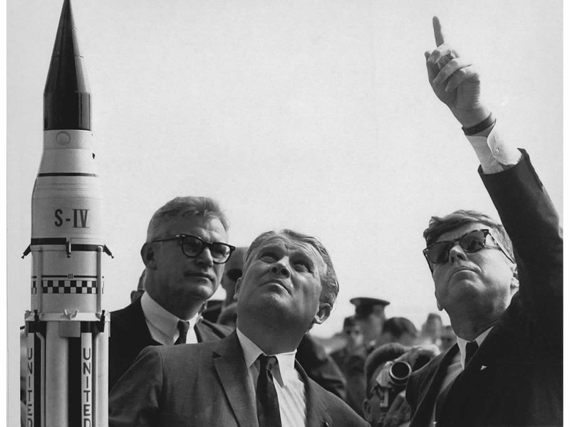 President John F. Kennedy learns about the Saturn launch system from Dr. Wernher von Braun.