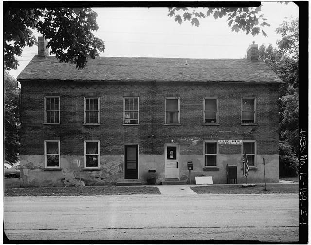 This undated photo from the Library of Congress shows the carpenter shop before the recent renovation. Note the variation in windows and the stucco that was added post colony period but removed during renovations.