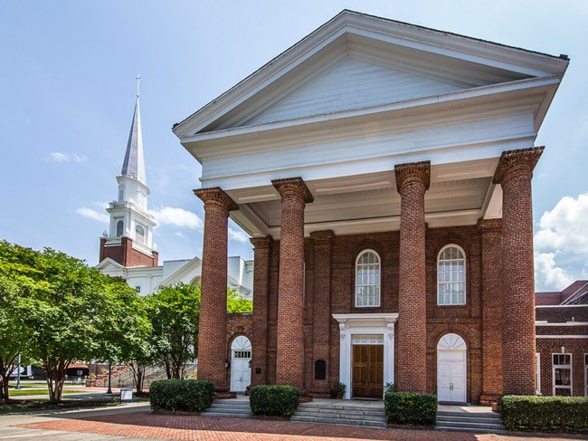 The original First Baptist Church, now the Boyce Chapel, was where state delegates met on December 17, 1860 to vote to secede from the United States. Church services are now held in the building with the spire in the background. 