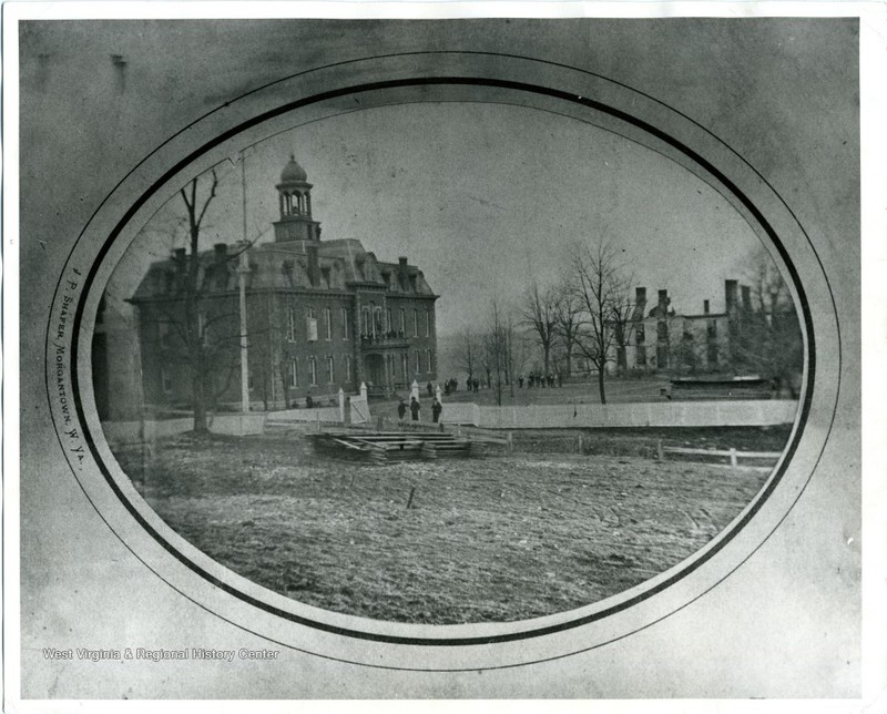 The burnt out foundation of the Woodburn Female Seminary following an 1873 fire. Martin Hall, WVU's oldest building appears on the left. Woodburn Hall was erected on the site of the seminary.