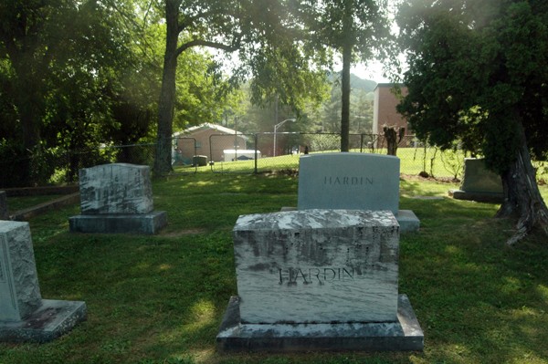 Near the back of the white section of the cemetery.The chain-link fence that separates the white section of the cemetery from the Black section can be seen in the background. 