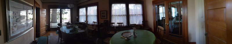 A panorama shot of the dining area connecting to the back-yard as well as the kitchen (door seen on left). 
