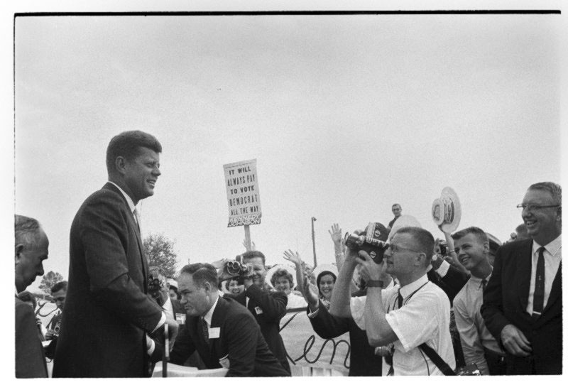 JFK smiles for the press before the rally at College Stadium.