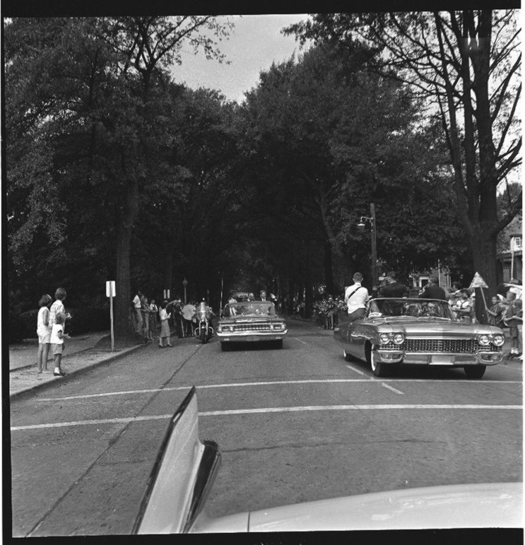 The motorcade of John F. Kennedy parades down 5th street in Greenville, North Carolina.