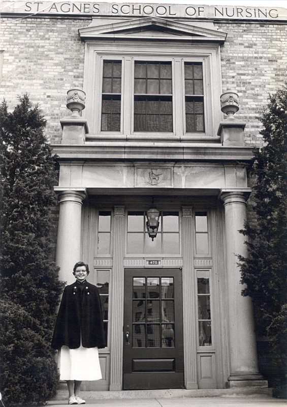A nursing student stands outside St. Agnes School of Nursing, 1950s.