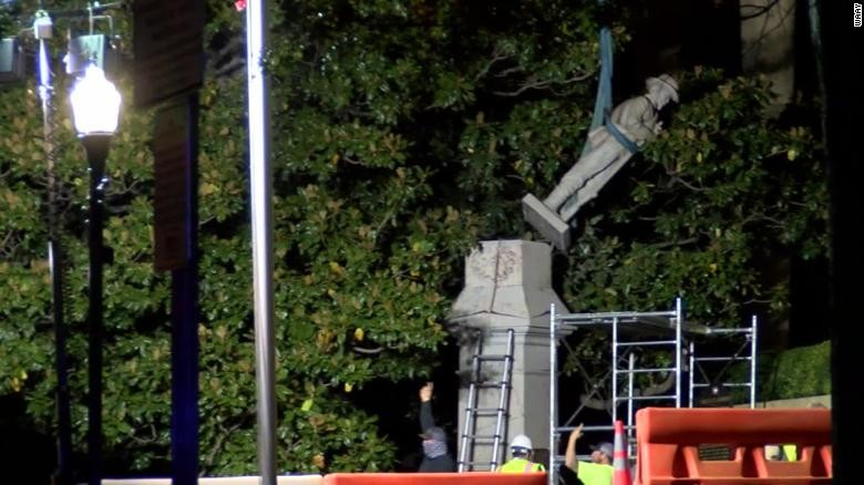 Crews remove the statue on the night of October 23, 2020