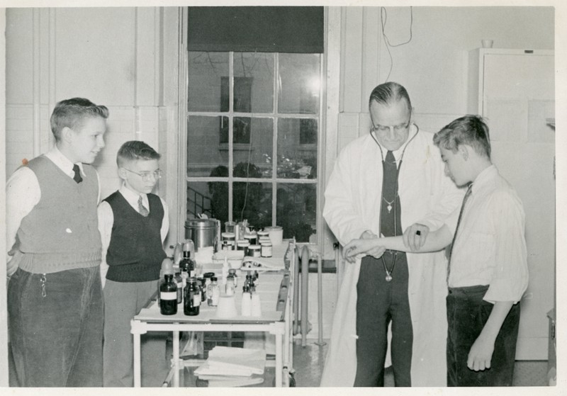 1960 photo of Infirmary doctor examining a student.