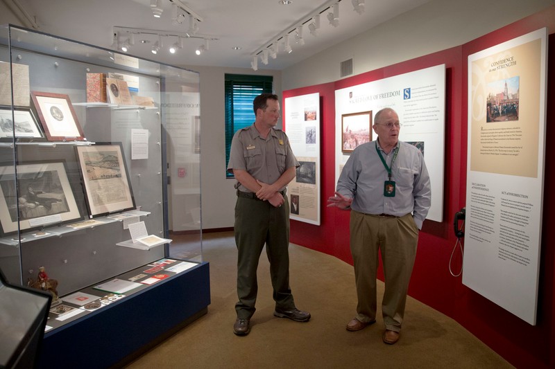 A park ranger discusses Kosciuszko's life with a visitor among the first floor interpretive exhibits.