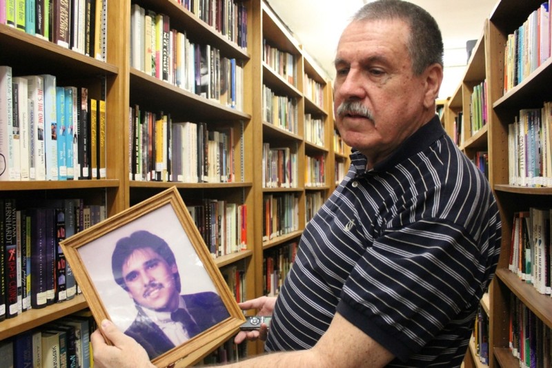 Library founder Michael Bohr with a photo of Chris T. Gonzalez. 