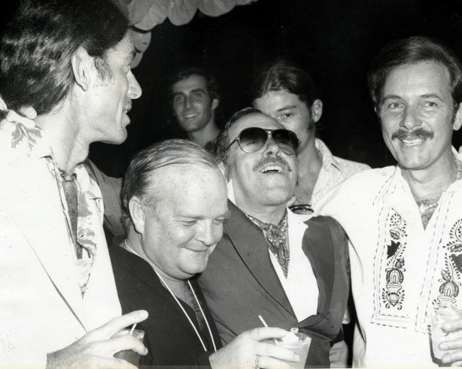 Tennessee Williams (center, with glasses) and Truman Capote (to Williams' right) share a private joke at the Hotel Monteleone.  