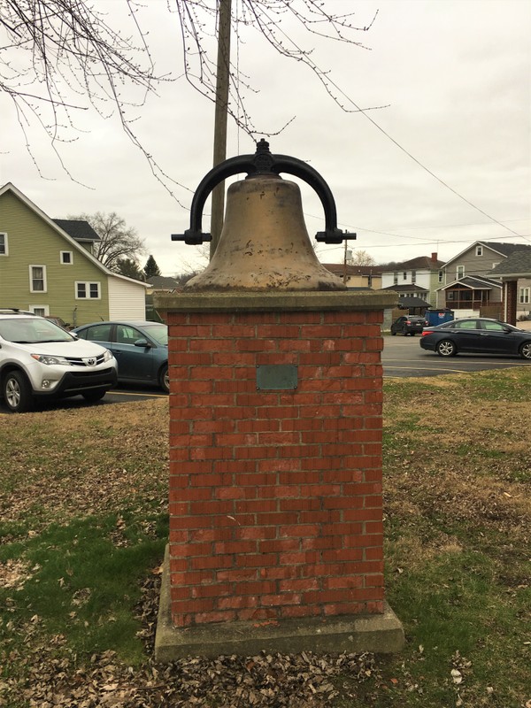 The bell from the original 1914 church building is on display behind the church.