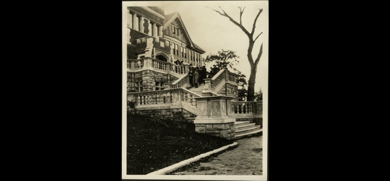 A group gathered on the steps at the front of the home