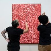 Two people looking at Alma Thomas's Read Rose Cantata painting.