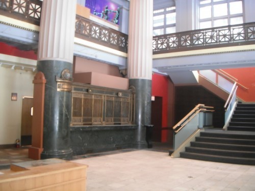 The three, green marble teller windows on the left and between the columns are all that remain of the original.