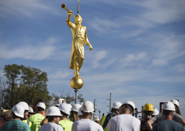 Construction crews prepare to place the Angel Moroni atop the temple